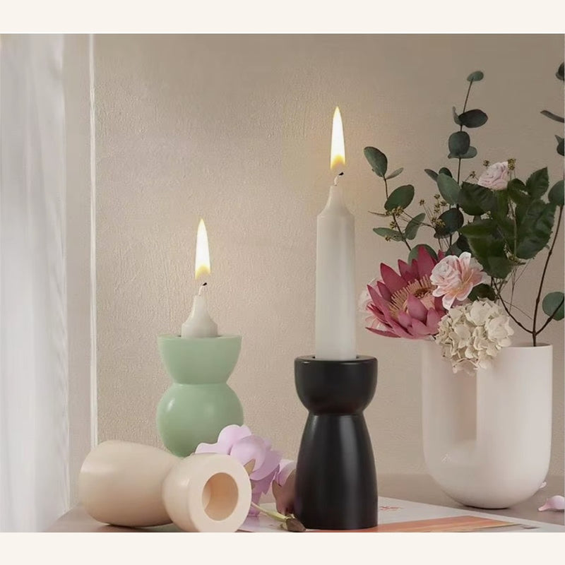 Handmade sculptural candlestick holders styled with pink flowers